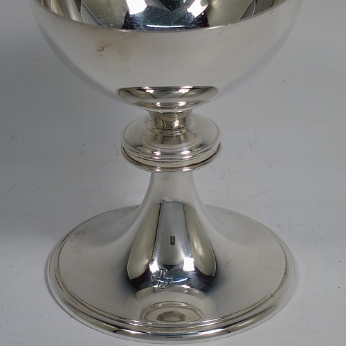 A small Sterling Silver altar chalice and paten, having a plain round bellied cup, a round column with a middle baluster, and a spreading round pedestal foot with reeded borders, together with a plain round original paten. Made by H. F. and Co. Ltd. of London in 1965. The dimensions of this fine hand-made silver chalice and paten are height 10 cms (4 inches), diameter of paten 11 cms (4.25 inches), with a total weight of approx. 203g (6.5 troy ounces). 