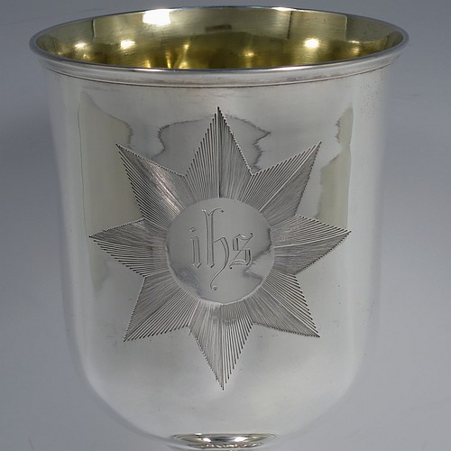 A large and handsome Antique Victorian Sterling Silver altar chalice, having a round straight-sided body with tucked under belly, an applied reeded top border, a gold-gilt interior, a middle baluster with fluted cabochon decoration, and a spreading round stepped pedestal foot. This beautiful silver chalice was made by Henry Holland of London in 1871. The dimensions of this fine hand-made antique silver altar chalice are height 23.5 cms (9.25 inches), diameter at lip 11 cms (4.25 inches), and it weighs approx. 382g (12.3 troy ounces). Please note that this has a classically engraved Christogram within sunburst on main body.