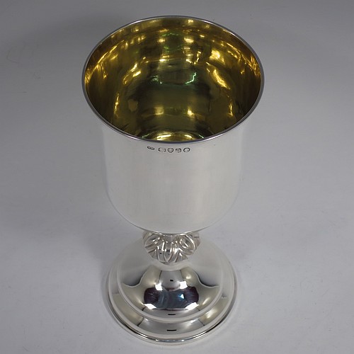 A large and handsome Antique Victorian Sterling Silver altar chalice, having a round straight-sided body with tucked under belly, an applied reeded top border, a gold-gilt interior, a middle baluster with fluted cabochon decoration, and a spreading round stepped pedestal foot. This beautiful silver chalice was made by Henry Holland of London in 1871. The dimensions of this fine hand-made antique silver altar chalice are height 23.5 cms (9.25 inches), diameter at lip 11 cms (4.25 inches), and it weighs approx. 382g (12.3 troy ounces). Please note that this has a classically engraved Christogram within sunburst on main body.