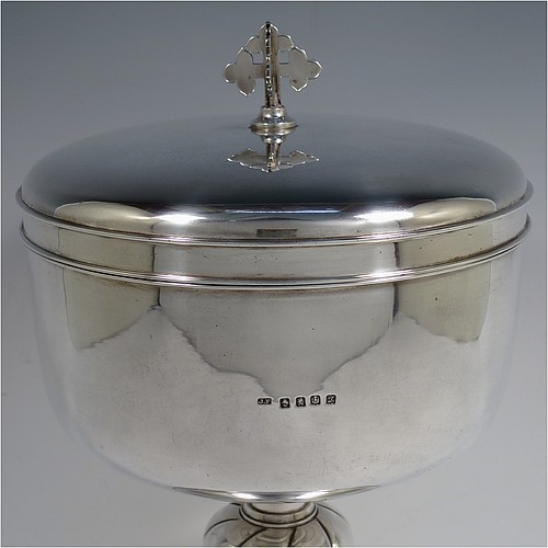 A very large and handsome Antique Edwardian Scottish Sterling Silver Ciborium, having a plain round body with a gold-gilt interior and applied reeded borders, sitting on a round pedestal foot with a swirl-fluted middle baluster, and a lift-off lid with double cruciform finial. Made by John Alexander Fettes of Glasgow in 1908. The dimensions of this fine hand-made and large antique silver ciborium and cover are height 28 cms (11 inches), diameter of cup 18.5 cms (7.25 inches), and it weighs a total of approx. 1,217g (39 troy ounces). Please note that this is the largest ciborium we have ever seen and is shown with a standard 75cl wine bottle for display purposes only and to give an indication of its size.