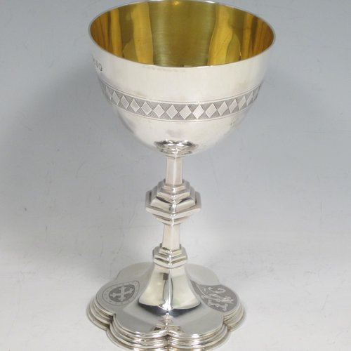 Antique Victorian sterling silver chalice and paten with wooden wafer box, having round bodies with hand-engraved christograms and bands diamond work, a gold-gilt interior to the chalice together with a hexafoil base, and the wafer box lid having a hand-engraved cross. Made by the Lias Brothers of London in 1873. The dimensions of this fine hand-made silver chalice and paten are height of chalice 14 cms (5.5 inches), diameter at lip 8 cms (3 inches), diameter of paten 13 cms (5 inches), with a total weight of silver being 236g (7.6 troy ounces).   