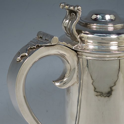 A Sterling Silver communion flagon for wine, in an early 17th century style having a straight-sided body, a scroll handle, a hinged & domed lid with cast scroll thumb-piece, and sitting on a collet foot. Made by J. Wippell & Co., of London in 1931. The dimensions of this fine hand-made communion wine flagon are height 25 cms (9.75 inches), length across handle & spout 18 cms (7 inches),and it weighs approx. 985g (32 troy ounces).   