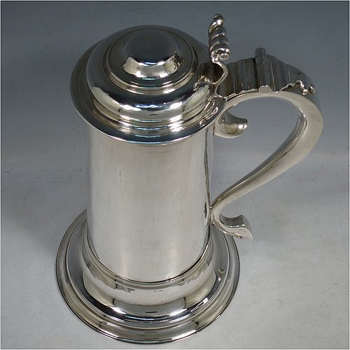 A Sterling Silver communion flagon for wine, in an early 17th century style having a straight-sided body, a scroll handle, a hinged & domed lid with cast scroll thumb-piece, and sitting on a collet foot. Made by J. Wippell & Co., of London in 1931. The dimensions of this fine hand-made communion wine flagon are height 25 cms (9.75 inches), length across handle & spout 18 cms (7 inches),and it weighs approx. 985g (32 troy ounces).   