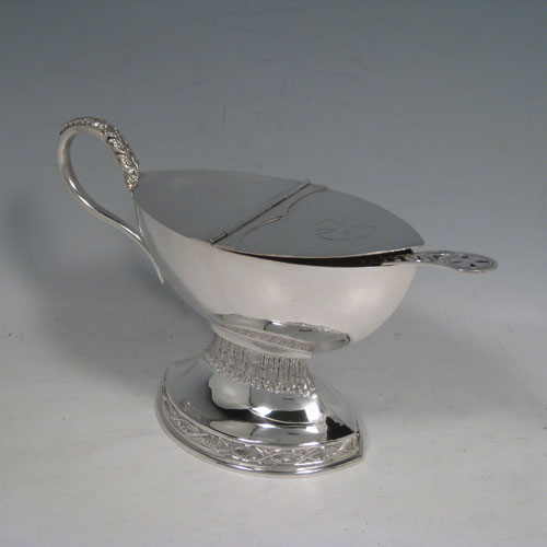 Sterling silver incense boat and spoon, having an oval plain body, a hinged half-lid, a cast scroll handle, sitting on a pedestal foot with hand-chased floral decoration. Together with a hand-chased spoon with pierced handle. All made in London in 1970. The dimensions of this fine silver incense boat are height 13 cms (5 inches), length 19 cms (7.5 inches), and width 8 cms (3 inches). With a total weight of 400g (13 troy ounces).   