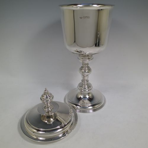 A very handsome, large, and heavy Antique Sterling Silver Ciborium, having a plain round body, a plain round lift-off lid with cast urn-shaped finial, a hand-chased central round baluster, and all sitting on a round stepped pedestal foot base. Made by Goldsmiths and Silversmiths of London in 1910. The dimensions of this fine hand-made antique silver ciborium are height 39 cms (15.3 inches), diameter of cup 15 cms (6 inches), and it weighs a total of approx. 1,552g (50 troy ounces).    