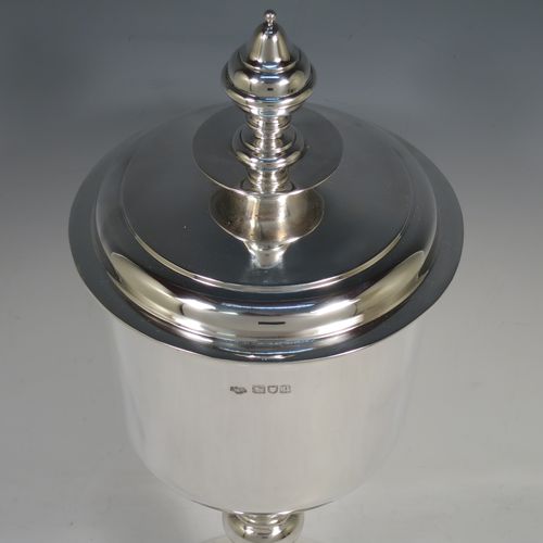 A very handsome, large, and heavy Antique Sterling Silver Ciborium, having a plain round body, a plain round lift-off lid with cast urn-shaped finial, a hand-chased central round baluster, and all sitting on a round stepped pedestal foot base. Made by Goldsmiths and Silversmiths of London in 1910. The dimensions of this fine hand-made antique silver ciborium are height 39 cms (15.3 inches), diameter of cup 15 cms (6 inches), and it weighs a total of approx. 1,552g (50 troy ounces).    