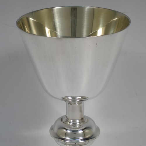 A handsome antique Sterling Silver altar chalice, having a plain round tapering cup with a gold-gilt interior, a middle plain round baluster, sitting on a round stepped pedestal foot. Made by Jesse Earls of London in 1919. The dimensions of this fine hand-made antique silver chalice are height 18 cms (7 inches), diameter at base 11.5 cms (4.5 inches), and  it weighs approx. 204g (6.6 troy ounces).    