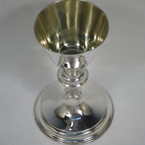 A handsome antique Sterling Silver altar chalice, having a plain round tapering cup with a gold-gilt interior, a middle plain round baluster, sitting on a round stepped pedestal foot. Made by Jesse Earls of London in 1919. The dimensions of this fine hand-made antique silver chalice are height 18 cms (7 inches), diameter at base 11.5 cms (4.5 inches), and  it weighs approx. 204g (6.6 troy ounces).    