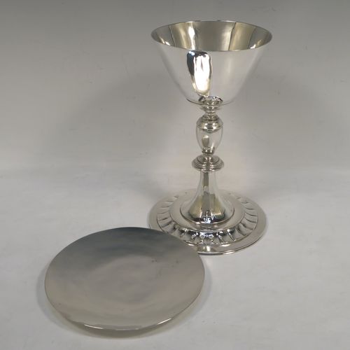 A very elegant Sterling Silver altar chalice and paten, having a plain round tapering cup, a middle plain round stepped baluster, sitting on a round pedestal foot with a band of hand-chased fluted decoration, together with an original plain round paten. This beautiful silver chalice and paten was made in London in 1957. The dimensions of this fine hand-made silver chalice and paten are height of chalice 19.5 cms (7.75 inches), diameter of cup at lip 10 cms (4 inches), diameter of paten 13.5 cms (5.3 inches), and with a total weight of approx. 507g (16.4 troy ounces).   