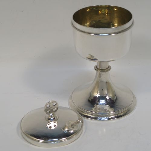 A small but handsome Sterling Silver Ciborium, having a round body with hand-hammered or planished decoration and reeded borders, a plain round lift-off lid with a cruciform finial, and all sitting on a round pedestal foot base. This elegant silver ciborium was made by John Wippell and Co. Ltd., of London in 1943. The dimensions of this fine hand-made silver ciborium are height 14.5 cms (5.75 inches), diameter of cup 7.5 cms (3 inches), and it weighs a total of approx. 237g (7.6 troy ounces).