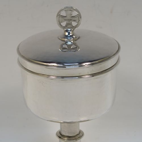 A small but handsome Sterling Silver Ciborium, having a round body with hand-hammered or planished decoration and reeded borders, a plain round lift-off lid with a cruciform finial, and all sitting on a round pedestal foot base. This elegant silver ciborium was made by John Wippell and Co. Ltd., of London in 1943. The dimensions of this fine hand-made silver ciborium are height 14.5 cms (5.75 inches), diameter of cup 7.5 cms (3 inches), and it weighs a total of approx. 237g (7.6 troy ounces).