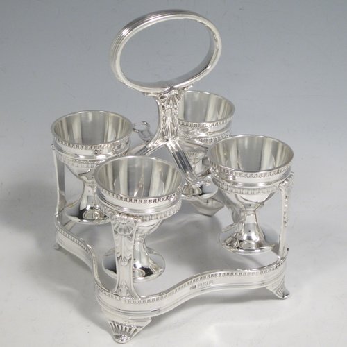 Sterling silver egg cruet set, having four round egg cups, sitting inside a frame with gadroon, shell, and anthemion leaf decoration, and a reeded loop handle, all sitting on four flange feet. Made by George Hancock of Sheffield in 1915. Please note that there are no spoons with this stand. The dimensions of this fine hand-made silver egg cruet set are height 16 cms (6.25 inches), the base is 11 cms (4.3 inches) square and the total weight is approx. 483g (15.6 troy ounces).   