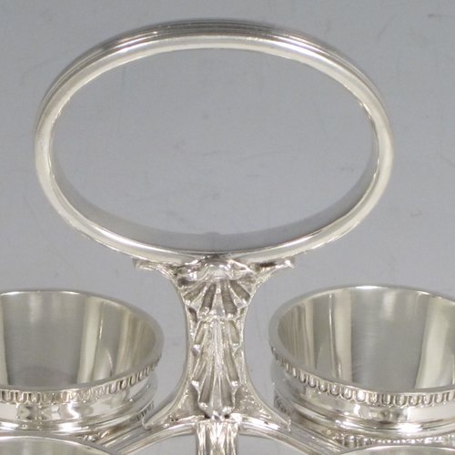 Sterling silver egg cruet set, having four round egg cups, sitting inside a frame with gadroon, shell, and anthemion leaf decoration, and a reeded loop handle, all sitting on four flange feet. Made by George Hancock of Sheffield in 1915. Please note that there are no spoons with this stand. The dimensions of this fine hand-made silver egg cruet set are height 16 cms (6.25 inches), the base is 11 cms (4.3 inches) square and the total weight is approx. 483g (15.6 troy ounces).   