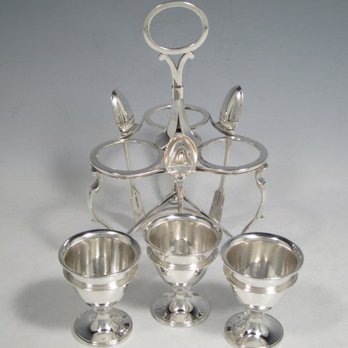 Antique Victorian sterling silver egg cruet set, having three removable plain round egg cups, and loop handle, all in a frame stand sitting on three scroll cushioned feet. The silver stand and egg cups are all made by Samuel Whitford of London in 1839, whilst the four spoons are in silver-plate. The dimensions of this fine hand-made silver egg cruet set are height 20 cms (8 inches), width 13.5 cms (5.3 inches), with a total weight of approx. 381g (12.3 troy ounces).   