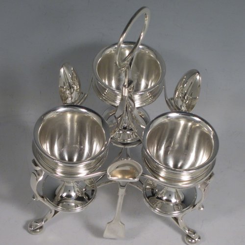 Antique Victorian sterling silver egg cruet set, having three removable plain round egg cups, and loop handle, all in a frame stand sitting on three scroll cushioned feet. The silver stand and egg cups are all made by Samuel Whitford of London in 1839, whilst the four spoons are in silver-plate. The dimensions of this fine hand-made silver egg cruet set are height 20 cms (8 inches), width 13.5 cms (5.3 inches), with a total weight of approx. 381g (12.3 troy ounces).   