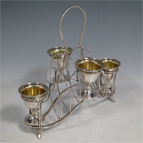 An Antique Georgian Sterling Silver egg cruet set, having four removable plain round egg cups with reeded borders and gold-gilt interiors, and all sitting in a wire-work frame toast-rack stand with four flange feet, and a looped carrying handle. Made by William Abdy of London in 1801. The dimensions of this fine hand-made antique silver egg cruet and toast set are height 22 cms (8.75 inches), length 23 cms (9 inches), width 14 cms (5.5 inches), with a total weight of approx. 500g (16 troy ounces).    