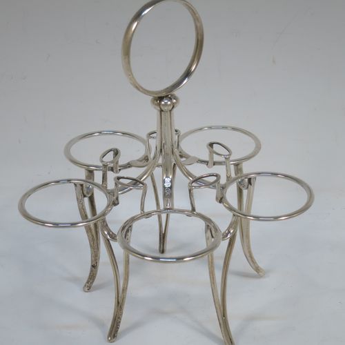 A very handsome Antique Victorian Sterling Silver egg cruet set, having five removable plain round egg cups with reeded borders and gold-gilt interiors, all sitting in a plain wire-work frame stand with five feet, together with five matching plain Old English pattern spoons. The cruet frame and egg cups made by the Barnard Brothers of London in 1859, and the spoons made by James Dixon and Sons of Sheffield in 1922. The dimensions of this fine hand-made antique silver egg cruet set are height 18 cms (7 inches), width 15 cms (6 inches), with a total weight of approx. 477g (15.4 troy ounces).  