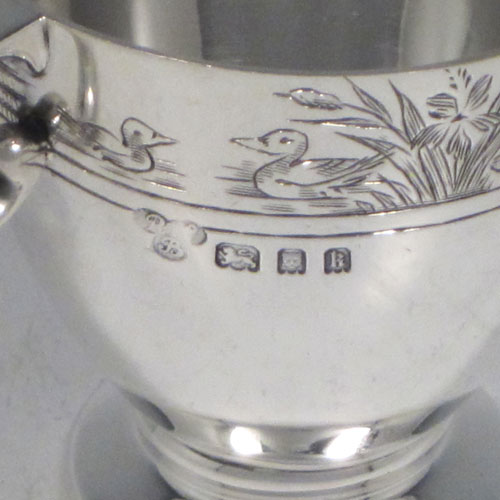 Sterling silver egg cup, having a plain round body with tapering sides, with a hand-engraved top border (showing ducks, ducklings, reeds, chickens, and chicks), with two scroll side-handles, and sitting on a pedestal foot. Made by R.W. Brookes for Harrods, London, in 1925. The dimensions of this fine hand-made silver egg cup are height 4.5 cms (1.75 inches), width 7 cms (2.75 inches), and it weighs approx. 44g (1.4 troy ounces).