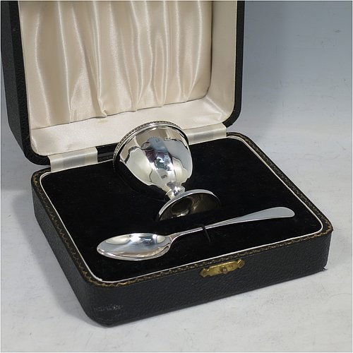 A Sterling Silver egg cup and spoon christening set, having a hand-chased panelled round egg cup, with an applied bead border, and a plain Old English pattern spoon. All fitted in their original cream satin and black velvet-lined presentation box. Made by the Adie Brothers of Birmingham in 1974. The dimensions of this fine hand-made silver egg cup & spoon christening set are length of spoon 11.5 cms (4.5 inches), height of egg cup 6 cms (2.3 inches), and the total weight is approx. 81g (2.6 troy ounce).   