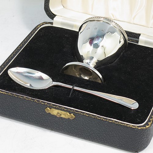 A Sterling Silver egg cup and spoon christening set, having a hand-chased panelled round egg cup, with an applied bead border, and a plain Old English pattern spoon. All fitted in their original cream satin and black velvet-lined presentation box. Made by the Adie Brothers of Birmingham in 1974. The dimensions of this fine hand-made silver egg cup & spoon christening set are length of spoon 11.5 cms (4.5 inches), height of egg cup 6 cms (2.3 inches), and the total weight is approx. 81g (2.6 troy ounce).   