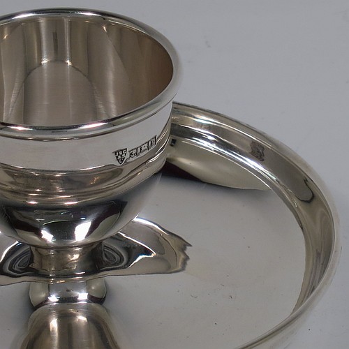 A Sterling Silver egg cup, having a plain round body with tapering sides, with an attached plain round plate with curved border, and sitting on a flat base. Made J. B. Chatterly of Birmingham in 1964. The dimensions of this fine hand-made silver egg cup are height 5 cms (2 inches), diameter 10 cms (4 inches), and it weighs approx. 87g (2.8 troy ounces).   