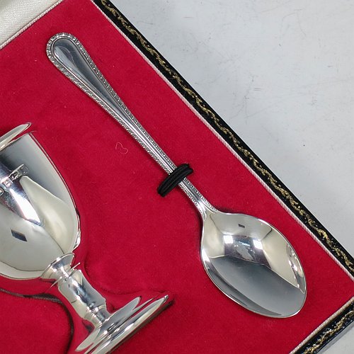 A Sterling Silver christening set, having an egg cup with gold-gilt interior, and a spoon with a rope-twist border. All fitted in their original cream satin and red velvet-lined presentation box. Made in Birmingham in 1974. The dimensions of this fine hand-made silver christening set are length of spoon 11 cms (4.3 inches), height of egg cup 6.5 cms (2.5 inches), and the total weight is approx. 36g (2 troy ounces).    