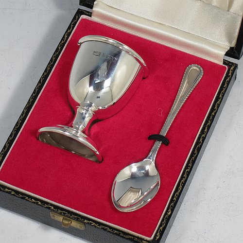 A Sterling Silver christening set, having an egg cup with gold-gilt interior, and a spoon with a rope-twist border. All fitted in their original cream satin and red velvet-lined presentation box. Made in Birmingham in 1974. The dimensions of this fine hand-made silver christening set are length of spoon 11 cms (4.3 inches), height of egg cup 6.5 cms (2.5 inches), and the total weight is approx. 36g (2 troy ounces).    