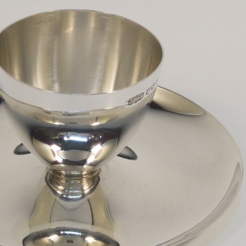 A Sterling Silver egg cup and plate, having a plain round body with tapering sides, with an attached plain round plate with curved border, and sitting on a flat base. This elegant silver egg cup was made by James Dixon Sons of Sheffield in 1943. The dimensions of this fine hand-made silver egg cup are height 4 cms (1.5 inches), diameter 9.5 cms (3.75 inches), and it weighs approx. 77g (2.5 troy ounces).  