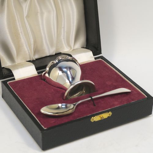 A handsome Sterling Silver egg cup and spoon, having a plain round egg cup with an applied wavey-edged border and a round pedestal foot, and a plain Old English pattern spoon with a gold-gilt bowl, all fitted in their original cream satin and maroon velvet-lined presentation box. This elegant silver egg cup and spoon christening set was made by Bistons Ltd., of Birmingham in 1966. The dimensions of this fine hand-made silver egg cup and spoon are length of spoon 11 cms (4.3 inches), height of egg cup 5 cms (2 inches), and the total weight is approx. 46g (1.5 troy ounce).   