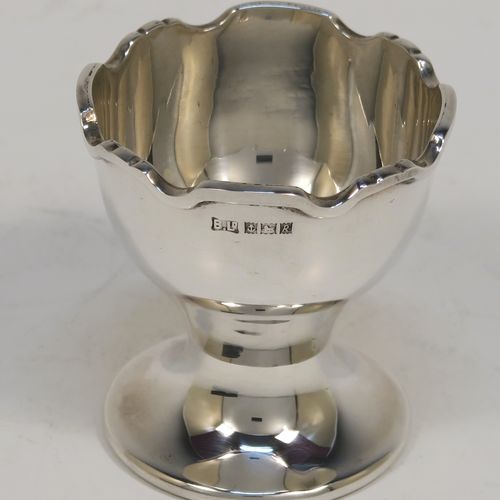 A handsome Sterling Silver egg cup and spoon, having a plain round egg cup with an applied wavey-edged border and a round pedestal foot, and a plain Old English pattern spoon with a gold-gilt bowl, all fitted in their original cream satin and maroon velvet-lined presentation box. This elegant silver egg cup and spoon christening set was made by Bistons Ltd., of Birmingham in 1966. The dimensions of this fine hand-made silver egg cup and spoon are length of spoon 11 cms (4.3 inches), height of egg cup 5 cms (2 inches), and the total weight is approx. 46g (1.5 troy ounce).   