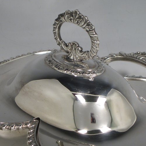 Antique Victorian silver plated double entree dish, having a very unusual double oval dish style, with removable cover and handle, applied gadroon and shell borders, a further side handle, and sitting on four cast lions-paw feet. Made in ca. 1890. The dimensions of this fine double entree dish and cover are height 15 cms (6 inches), length 23 cms (9 inches), and width 21.5 cms (8.5 inches).