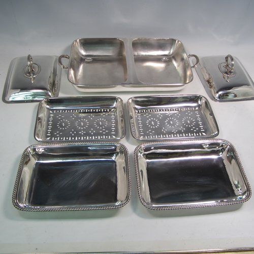 Sterling silver pair of entree dishes with covers and handles, sitting in an original plain rectangular hot-water warming frame, with applied gadroon borders and hand-pierced liners, having cast side-handles, and all sitting on four cushion feet. Made by D. & J. Wellby of London in 1916. The dimensions of this fine hand-made silver entree dish set are length 36 cms (14 inches), width 20 cms (8 inches), height including cover handles 12 cms (4.75 inches), and it weighs a total of approx. 1,965g (63 troy ounces).    