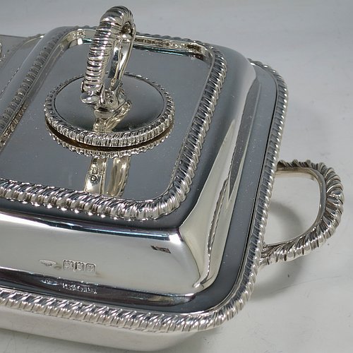 An Antique Edwardian Sterling Silver pair of entrï¿½e dishes with covers on a silver-plated warming stand for hot water, having rectangular bodies with applied gadroon borders, and with removable bayonet-fit handles. All in original condition and made by Goldsmiths & Silversmiths of London in 1902. The dimensions of this fine pair of hand-made antique silver entree dishes on a silver plated warming stand are length (inc. handles) 34 cms (13.5 inches), width 20 cms (8 inches), height 12 cms (5 inches), and the entree dishes weigh approx. 1,721g (55.5 troy ounces).   