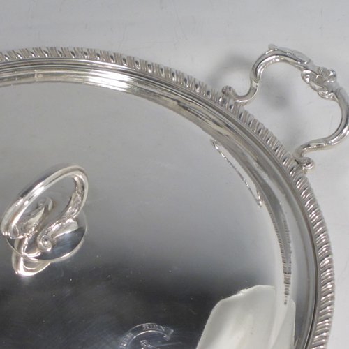 Antique Georgian sterling silver pair of entree or hash dishes with covers, having round bodies with applied gadroon borders and cast scroll side-handles, with plain domed lift-off covers having cast asparagus handles, an all sitting on flat bases. Made by Charles Wright of London in 1771. The dimensions of this pair of fine hand-made antique silver entree dishes and covers are diameter 24 cms (9.5 inches), height including cover handle 10 cms (4 inches), and they weigh a total of approx. 1,738g (56 troy ounces). Please note that both the bases and covers are crested.