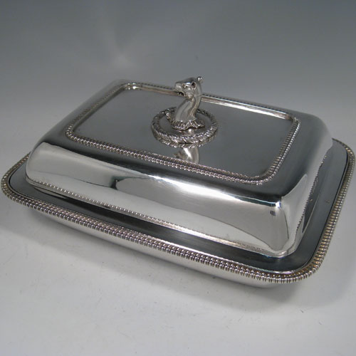 Antique Georgian sterling silver entree dish and cover, having a rectangular body, with gadroon edges, and removable cast leopards head handle. Made by John Foskett & John Stewart of London in 1809. The dimensions of this fine antique silver entree dish and cover are length 28 cms (11 inches), width 21.5 cms (8.5 inches), height including handle 12 cms (4.75 inches), and its wWeight is approx. 1,849g (59 troy ounces).