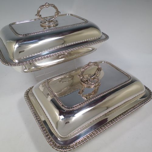 A handsome pair of Antique Georgian Sterling Silver entree dishes with covers, having rectangular bodies with rounded corners and applied gadroon borders, cast bayonet-fit removable asparagus style loop handles, and sitting on flat bases. Made by Richard Crossley of London in 1811. The dimensions of this pair of fine hand-made antique silver entree dishes and covers are length 29 cms (11.5 inches), height including handle 14 cms (5.5 inches), width 21 cms (8.25 inches), and they weigh a total of approx. 2,808g (90 troy ounces).   