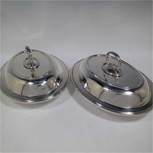 An Antique Victorian Sterling Silver pair of entree dishes, having plain oval bodies, with lift-off lids, removable bayonet-fit handles, applied reeded borders, and sitting on flat bases. Made by the Savory Brothers of London in 1893. The dimensions of this fine pair of hand-made antique silver entree dishes and covers are length 29 cms (11.5 inches), width 22 cms (8.75 inches), and they weigh a total of approx. 3,472g (112 troy ounces). 