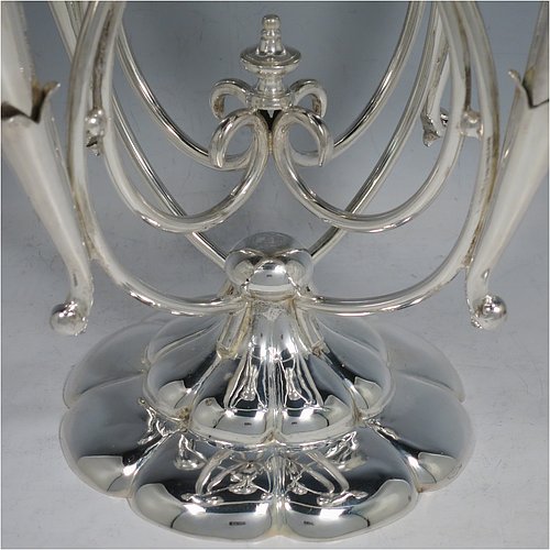 An Antique Victorian Silver Plated Art Nouveau flower vase epergne center-piece, having five removable flower vases, with a central larger vase, all sitting on a base with wire-work scrolls and melon-style fluting. All made in ca. 1890. The dimensions of this fine hand-made silver-plated flower epergne are height 37 cms (14.5 inches), and spread across vases 28 cms (11 inches).  