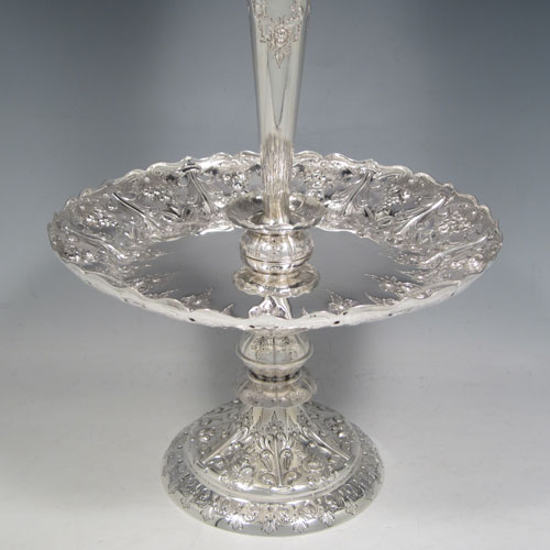 Antique Victorian sterling silver epergne flower vase centerpiece, having a central flower vase with hand-cut crystal holder, a hand-chased dish surrounding the latter with fruit and floral decoration, all sitting on a pedestal foot with matching hand-chased work. Made by Martin and Hall of London in 1881. The dimensions of this fine hand-made silver center-piece are height 47 cms (18.5 cms), diameter 23.5 cms (9.25 inches), and it weighs approx. 788g (25.3 troy ounces).