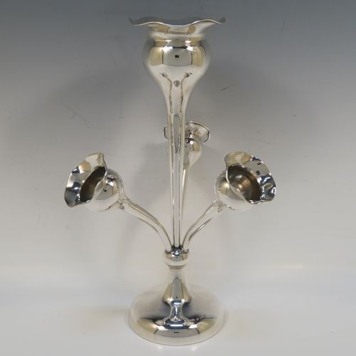 A pretty Antique Sterling Silver flower vase epergne center-piece in a plain round style, having three removable side flower vases that slot into the base of a central larger vase, and all sitting on a plain round pedestal foot. This beautiful antique silver flower epergne was made by Joseph Gloster of Birmingham in 1916. The dimensions of this fine hand-made sterling silver flower centre-piece epergne are height 29.5 cms (11.5 inches), spread across vases 19 cms (7.5 inches), and it weighs approx. 435g (14 troy ounces).   