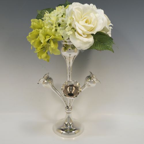 A pretty Antique Sterling Silver flower vase epergne center-piece in a plain round style, having three removable side flower vases that slot into the base of a central larger vase, and all sitting on a plain round pedestal foot. This beautiful antique silver flower epergne was made by Joseph Gloster of Birmingham in 1916. The dimensions of this fine hand-made sterling silver flower centre-piece epergne are height 29.5 cms (11.5 inches), spread across vases 19 cms (7.5 inches), and it weighs approx. 435g (14 troy ounces).   