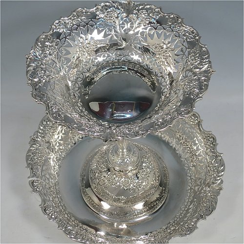 An Antique Victorian Sterling Silver epergne centerpiece, having a central upper dish attached to a larger lower dish, with hand-cut and hand-chased floral and fruit decoration, all sitting on a flat base. Made by Martin and Hall of Sheffield in 1896. The dimensions of this fine hand-made antique silver centre-piece are height 23 cms (9 inches), diameter at base 25 cms (9.75 inches), and it weighs approx. 713g (23 troy ounces).   