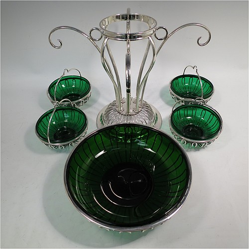 A very handsome and unusual Antique Edwardian Sterling Silver table Epergne centrepiece in an Art Nouveau style, having a removable central round wire-work basket and four matching removable swing baskets on side arms, all with dark green glass liners, and sitting on a spreading round base. Made by William Hutton of London in 1910. The dimensions of this fine hand-made antique silver Epergne table centrepiece are height 29 cms (11.5 inches), width across arms 38 cms (15 inches), and it weighs a total of approx. 1,954g (63 troy ounces)    