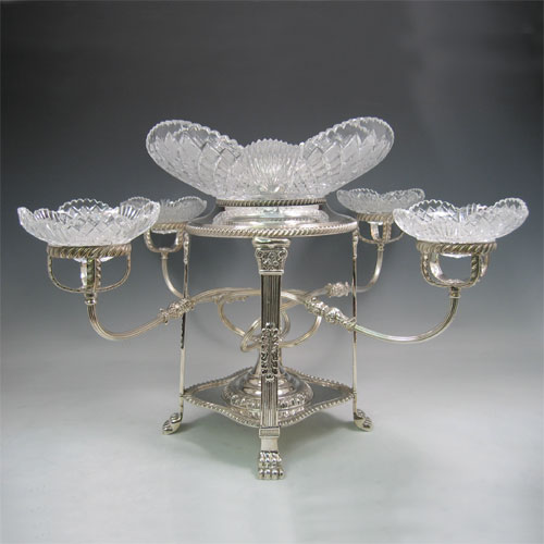 An Antique Victorian Silver-Plated table centre-piece epergne with five hand-cut crystal bowls, sitting in a Regency style frame with applied gadroon borders, swirl reeded arms, and all sitting on four lions paw feet. Made circa 1890. The dimensions of this fine hand-made antique silver plated epergne are height 38 cms (15 inches), and spread across bowls 58 cms (23 inches).