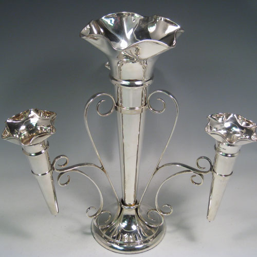    Sterling silver flower vase epergne with one large central vase and three smaller side vases. All vases are removable. Made by Walker and Hall of Sheffield in 1918. Height 35.5 cms (14 inches), spread across arms 33 cms (13 inches). 