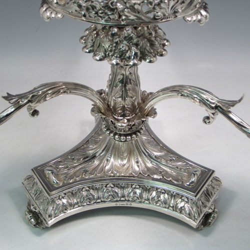 Antique Georgian sterling silver epergne centerpiece, having four hand-cut crystal bowls including a large central bowl for flowers or fruit and three smaller bowls for sweets or nuts, with each arm being removable, and all sitting on a very handsome base with hand-chased anthemion leaf and scroll work. Made by the famous silversmith Matthew Boulton of Birmingham in 1817. The dimensions of this fine hand-made silver center-piece are height 38 cms (15 inches), spread across arms 51 cms (20 inches), and it weighs approx. 2,820g (91 troy ounces).