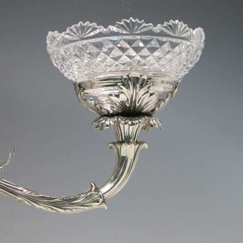 Antique Georgian sterling silver epergne centerpiece, having four hand-cut crystal bowls including a large central bowl for flowers or fruit and three smaller bowls for sweets or nuts, with each arm being removable, and all sitting on a very handsome base with hand-chased anthemion leaf and scroll work. Made by the famous silversmith Matthew Boulton of Birmingham in 1817. The dimensions of this fine hand-made silver center-piece are height 38 cms (15 inches), spread across arms 51 cms (20 inches), and it weighs approx. 2,820g (91 troy ounces).