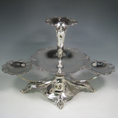 Sterling silver Art Nouveau style epergne, having a removable central bowl and vase, with two removable dishes on side arms, with applied hand-pierced borders, and sitting on a spreading base with matching pierced work. Made by Elkington and Co., of Birmingham in 1914. Height 37 cms (14.5 inches), width 54 cms (21.25 inches), depth 28 cms (11 inches). Total weight approx. 1,720g (55.5 troy ounces)