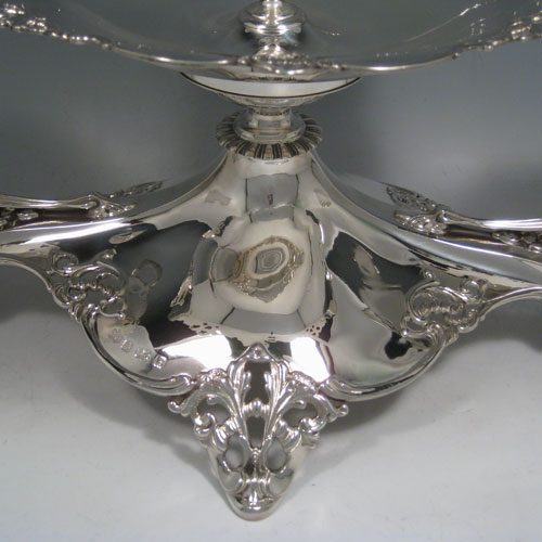 Sterling silver Art Nouveau style epergne, having a removable central bowl and vase, with two removable dishes on side arms, with applied hand-pierced borders, and sitting on a spreading base with matching pierced work. Made by Elkington and Co., of Birmingham in 1914. Height 37 cms (14.5 inches), width 54 cms (21.25 inches), depth 28 cms (11 inches). Total weight approx. 1,720g (55.5 troy ounces)