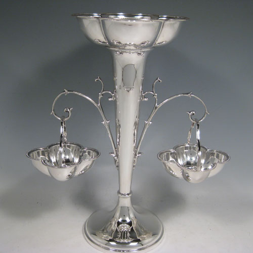 Sterling silver table epergne, having a central vase for flowers, with two removable hanging side baskets, with applied bead borders, and sitting on a pedestal foot. Made by William Hutton and Sons of Sheffield in 1923. Height 30 cms (11.75 inches), width 26 cms (10.25 inches). Total weight approx. 632g (20.4 troy ounces).   